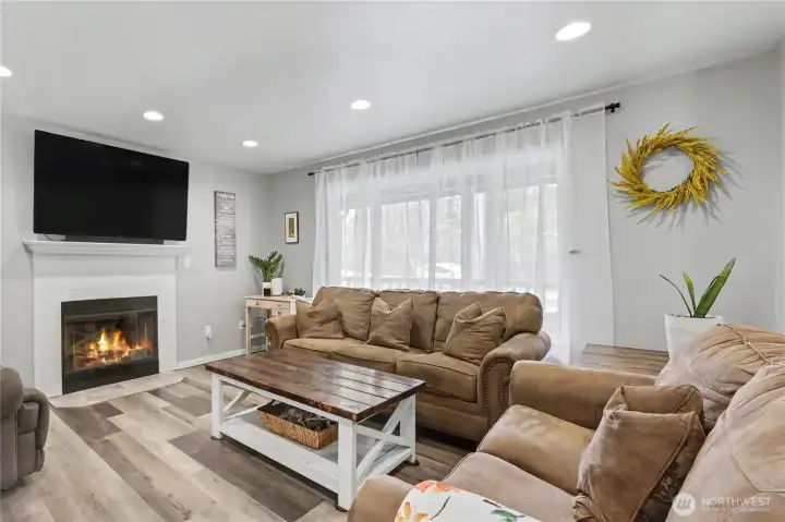 As you enter, you will find open-concept living with your family room feeding into your dining room, I really love a natural WOOD fireplace for cooler days and nights, the large windows and all the recessed lighting.