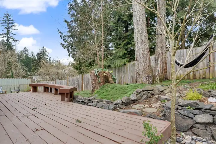 View of your massive deck and back yard, fully-fenced and I love the built-in seating and hammock!