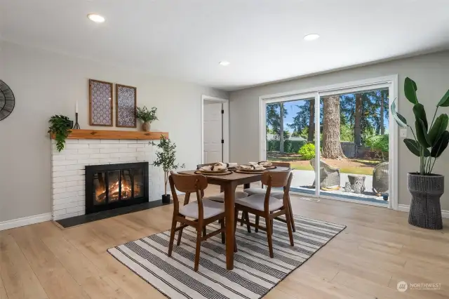 The cozy fireplace evokes serenity while dining and enjoying the backyard view