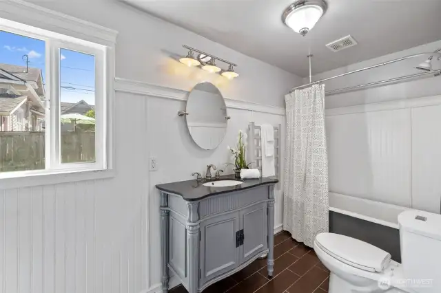 Main floor bathroom with tile floor and period vanity.