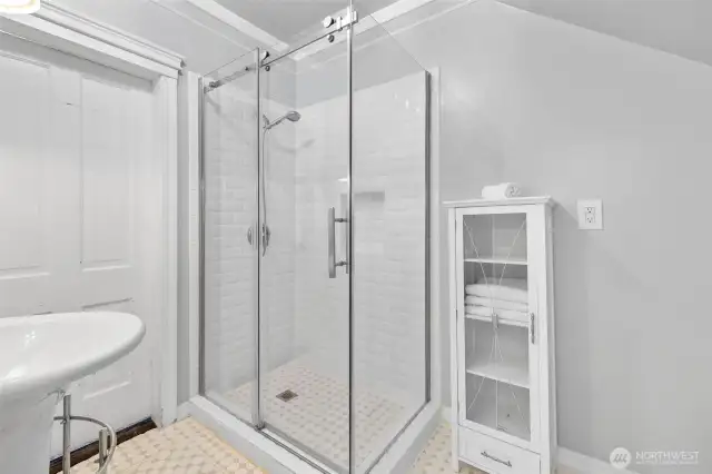 Large tiled shower; door on left is to the hallway.