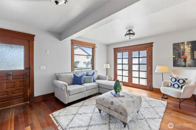 View looking toward street, showing original door, baseboards and window trim.