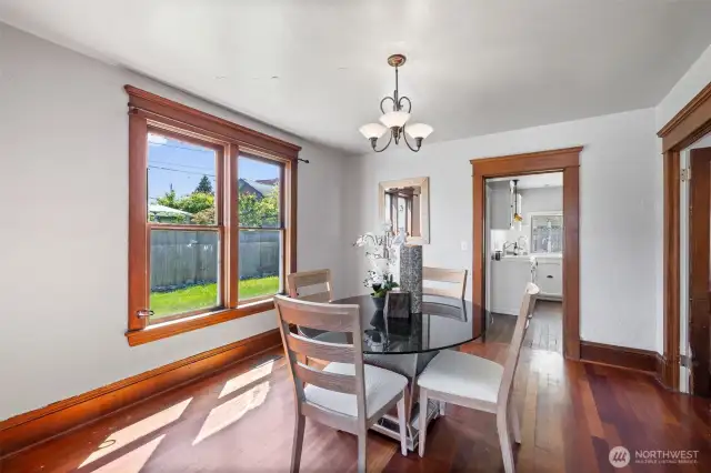 Good-sized dining room with hardwood floor, original trim and period lighting. Main floor bedroom is to the right, kitchen and full bath are straight ahead.