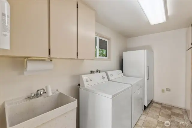 Just off the kitchen you will find a large laundry room with utility sink, additional upright freezer, washer and dryer.  All appliances stay.  Storage cabinets and a counter for folding laundry or crafts is to the right.
