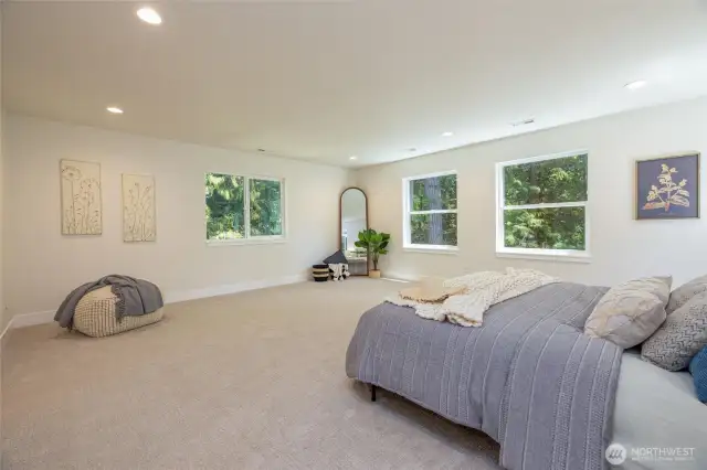 Massive primary bedroom with forest views.