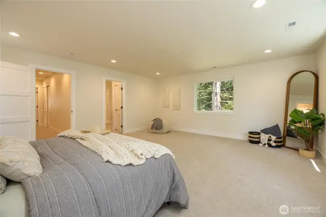 Massive primary bedroom with forest views.