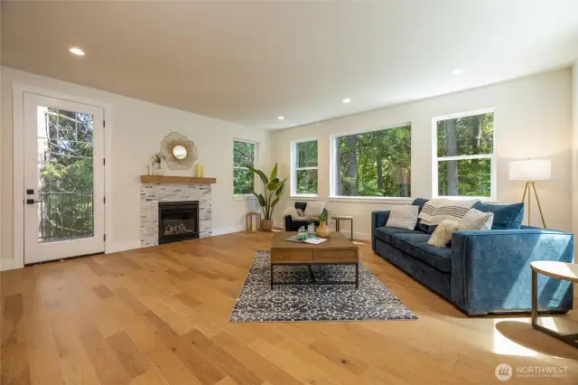 Living room with gas fireplace and forest views