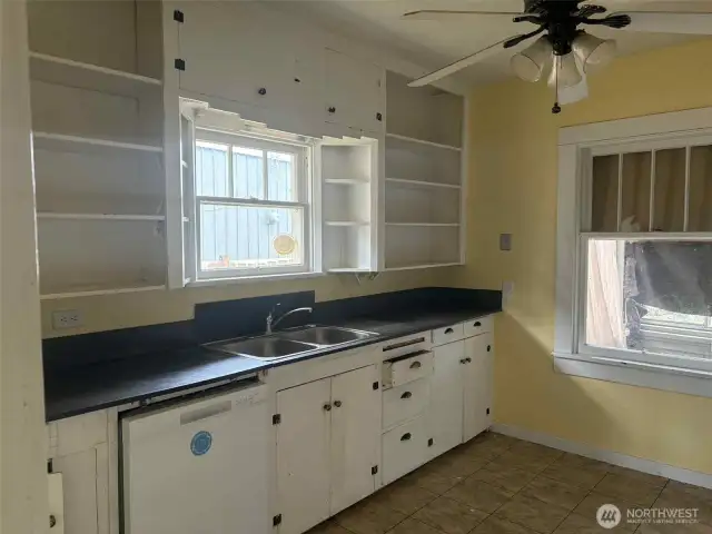 This vintage kitchen is full of charm and ready for a refresh! With open shelving, natural light, and original cabinetry, it's the perfect canvas for a creative makeover. Bring your ideas and make it shine!