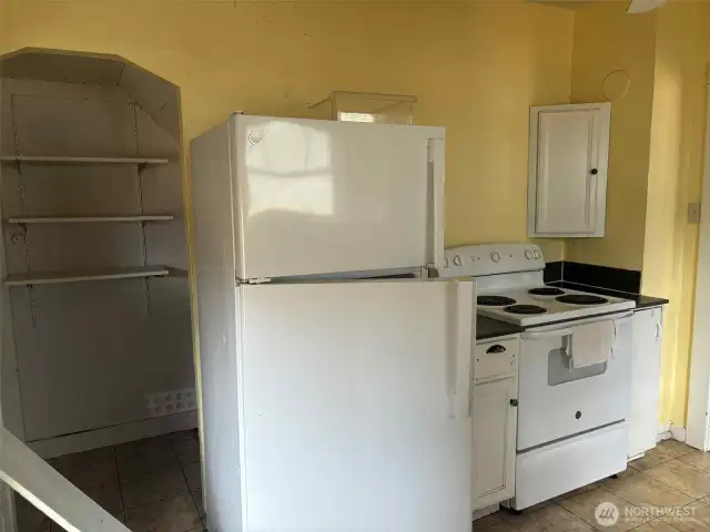 You can keep the vintage charm or there is plenty of space if you would like to make a completely updated kitchen that fits your needs. Whatever you choose there are options here! The nook to the left leads to a stairwell to the basement.