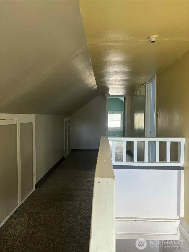At the top of the stairs is a fully finished second floor with storage on the sides and a loft area that opens to the two upper bedrooms