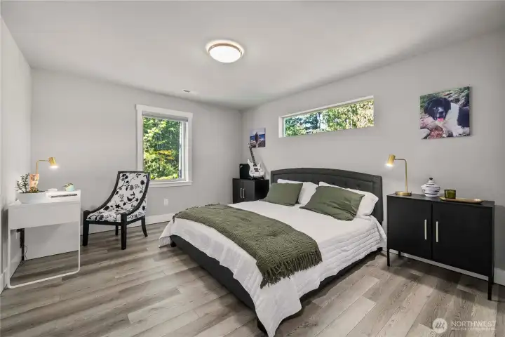 Upstairs Lg bedroom - this is a kingsize bed! With a view of the trail head and trees