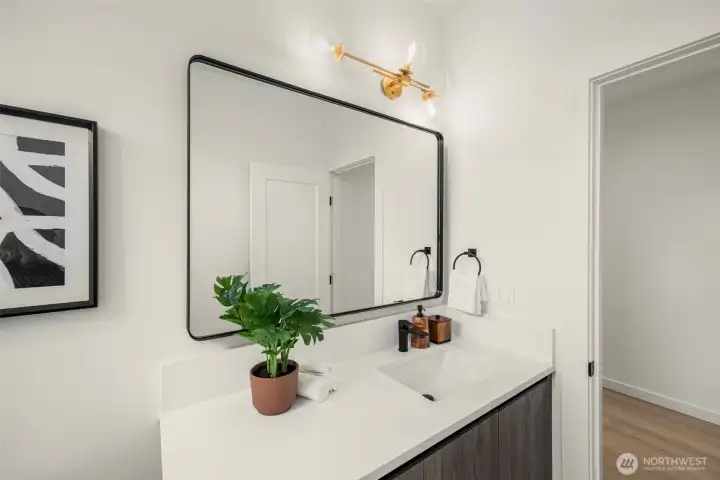 Clever design shines in this stylish powder bath, where a modern mirror and warm tones add a touch of personality.