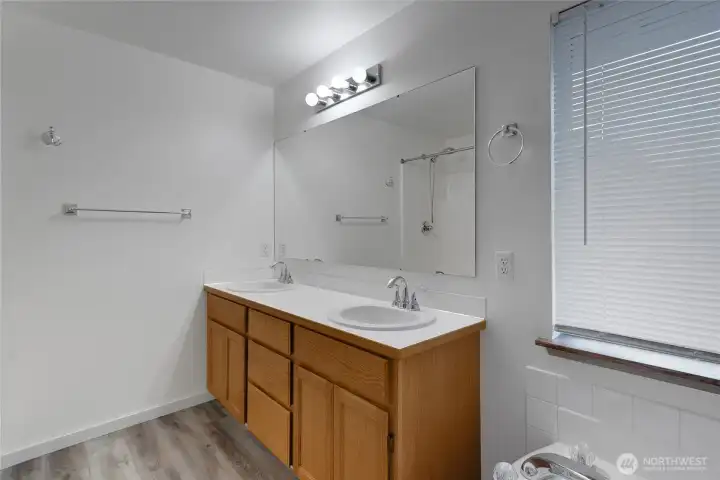 Primary bathroom with soaking tub and double vanity; separate shower not shown.