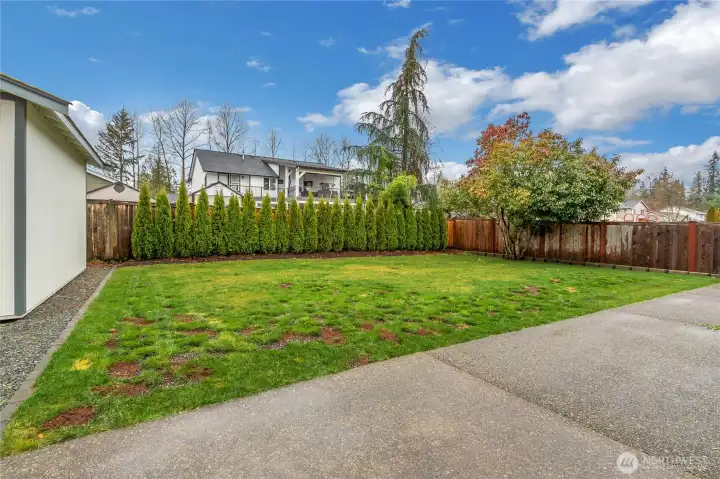 Fully fenced backyard with level lawn, large patio, and full irrigation system.