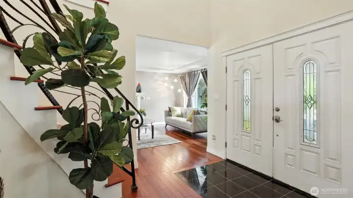 Grand entry with sweeping staircase and soaring ceiling.