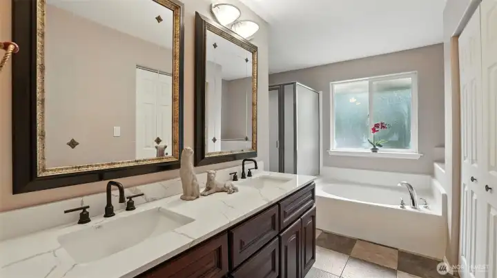 Full bath with dual sink vanity, tub, and separate shower.