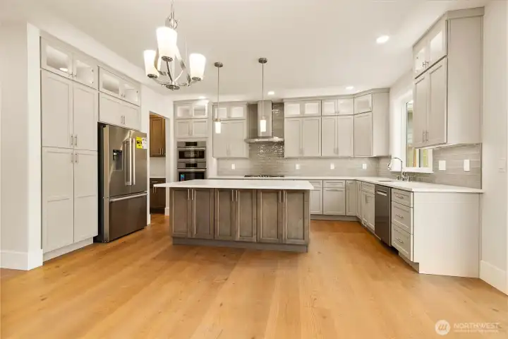 High-end Bosch stainless steel appliances anchor a beautifully designed kitchen, offering abundant storage and stunning, full-height illuminated cabinetry.