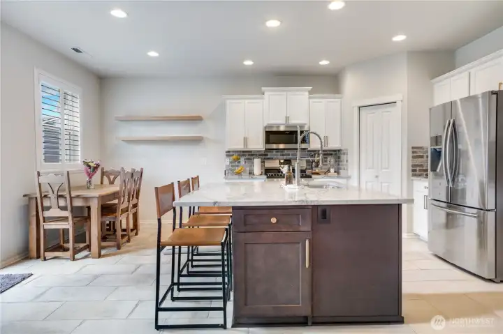 Large island was created with built-ins including space for the garbage. The cabinet space combined with the walk —in pantry create ample room for food and kitchen storage.
