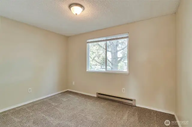 The spacious guest bedroom overlooks mature landscaping.