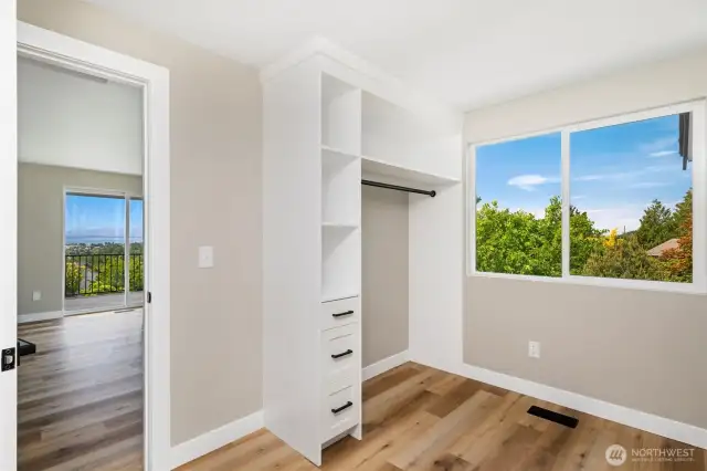 Generous walk-in closet with built-in organization and ample space for year-round wardrobe storage.