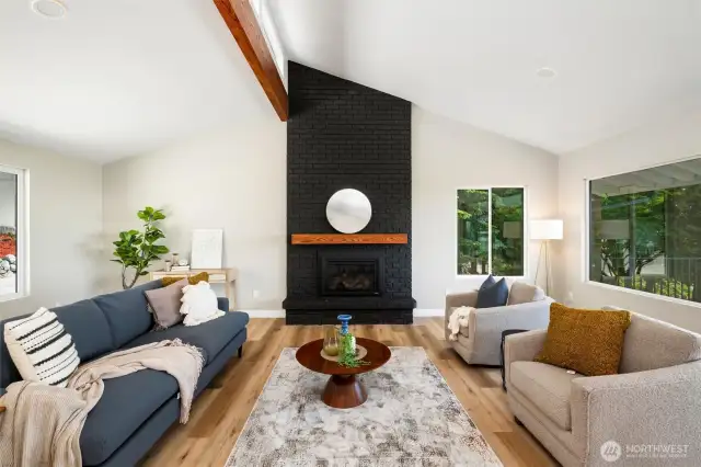 Cozy up by the gas fireplace in this stunning living room, framed by oversized windows that flood the space with natural light and showcase tranquil outdoor views.
