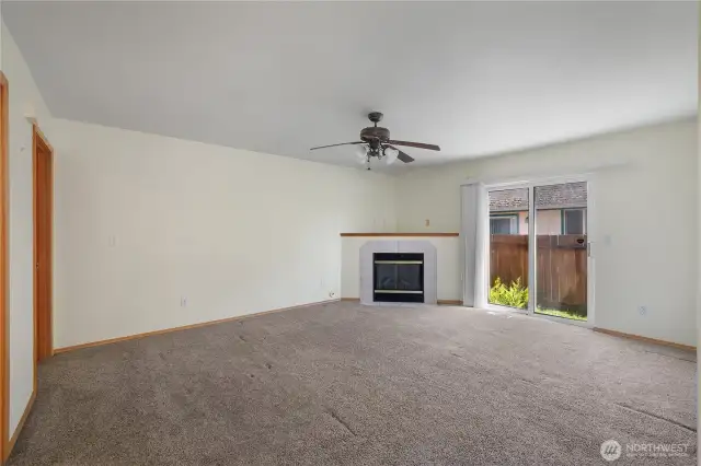 The LR features a slider to the side yard, a ceiling fan and a Natural Gas FP!