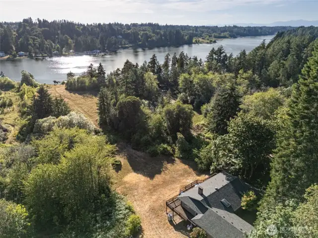 Henderson Inlet offers one of the most peaceful stretches of South Sound shoreline, and this aerial view captures why it’s so special. A private easement path connects the beach to property of the home above, surrounded by trees and set apart from anything else nearby. The South Bay area is known for its quiet roads, close-knit community, and access to nature in every direction. On clear days, you’ll spot Mt. Rainier rising in the distance, just above the treetops. It’s a location that feels deeply rooted and rare.
