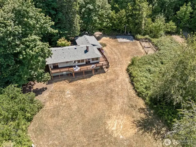 From this angle, the property’s privacy becomes clear. Surrounded by a mix of evergreens, fruit trees, and mature hardwoods, the home sits gently into the landscape. Watch for eagles gliding overhead or herons near the inlet. Nature isn’t just nearby. It’s part of the everyday view.