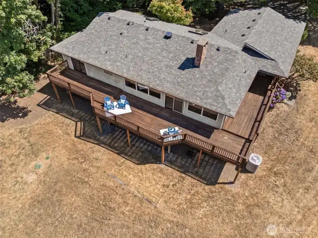 The wraparound deck stretches across the back of the home and connects seamlessly to a side entrance on the upper level, making outdoor living part of the everyday layout. There’s room here to host a crowd, set up container gardens, or simply take in the quiet setting. Open, sunny, and surrounded by trees, it’s a space with real range.