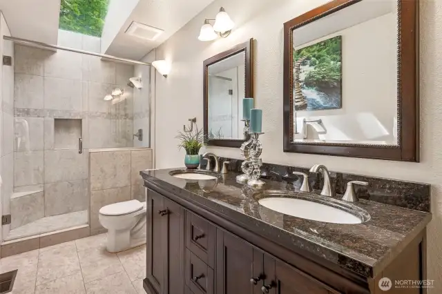 This main floor bath was given the upgrade it deserved. Tile flooring, a spacious tile and glass shower under a skylight, and a double sink vanity with espresso-toned cabinetry all work together to create a crisp, cohesive space. Undermount sinks keep the lines clean, and storage underneath means it’s beautiful and functional. It’s a refresh done right, simple, timeless, and built to last.
