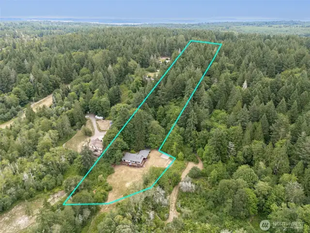 This view says it all. From the waterline, the easement trail leads through native trees toward the house, with 110 acres of conservation land stretching out to the right. It’s a protected, peaceful setting with real privacy and beauty that doesn't need a single improvement.