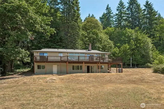 The back of the home reveals two separate entrances to the daylight basement, giving you serious flexibility for multi-generational living, guest space, or future ADU potential. Open, sunny areas near the home are ready for garden beds, an outdoor kitchen, or whatever your outdoor vision looks like. Surrounded by trees but with plenty of usable space, this property gives you privacy without sacrificing practicality.