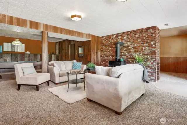 The lower level brings in square footage and serious versatility. With a separate entrance, neutral finishes, and multiple zones within one large space, it’s ideal for multi-generational living, guest space, or future ADU conversion. The brick fireplace wall adds a strong design element, and the mix of wood paneling, from rustic to vintage diagonal, it gives it warmth and texture.