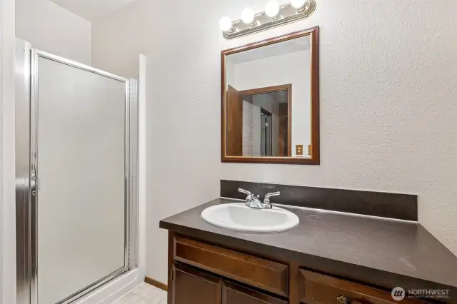 The downstairs bathroom keeps it clean and practical with a walk-in shower and glass door, a wide vanity with plenty of counter space, and storage that actually holds more than a toothbrush. Vinyl flooring makes upkeep simple, and white walls keep the space feeling open and fresh. Whether it’s used for guests or part of a future ADU setup, it’s ready to go.