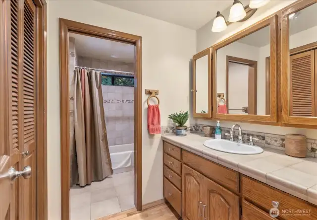 A complete guest split bathroom ensures convenient sharing! It boasts double vanities with extra-long counter space and a privacy door that separates the bathtub and toilet.