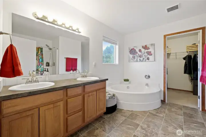 This generous, 5-piece bathroom offers large garden tub, double vanity, and shower (seen in mirror).