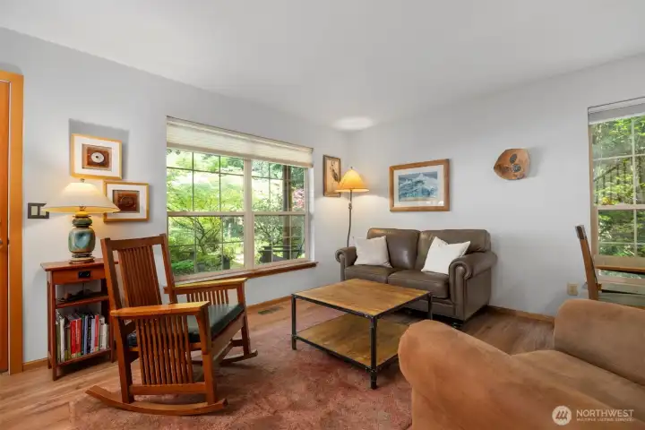 The living room is spacious and light and bright, as it has large windows that look out to the gorgeous landscaping.