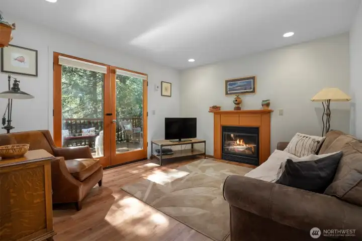 The family room is also light and bright and has a lovely gas fireplace with a wood surround and mantle. The French doors open onto an expansive deck that over looks the forested parcels that surround the home.