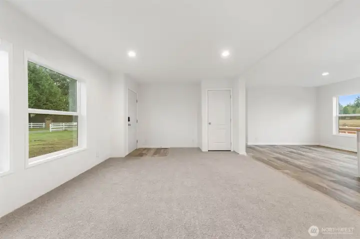 View of the living room shows coat closet and to the right a partial view of the dining room and kitchen.