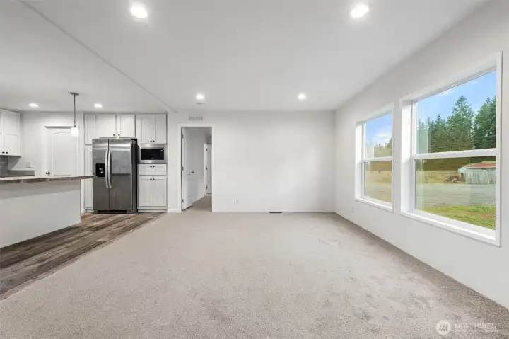 From the living room is a view of the primary bedroom entrance, which is on the opposite end of the other bedrooms allowing complete privacy.