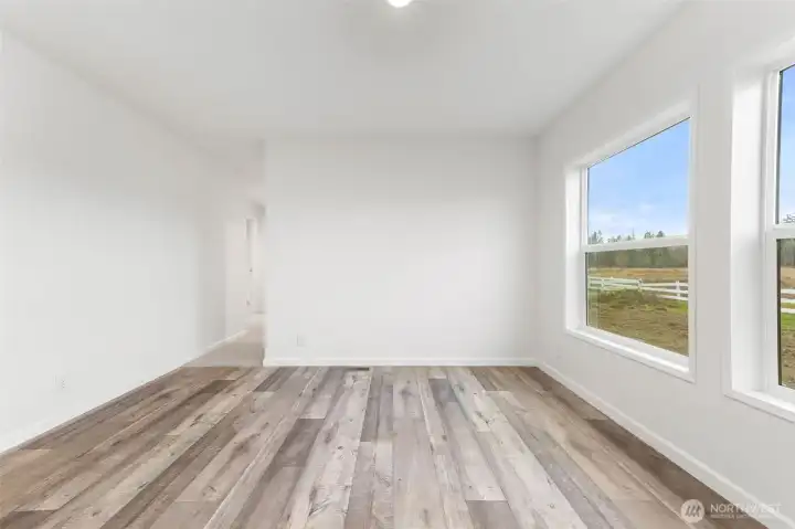 Dining area with two large windows allowing views of the back of the property.