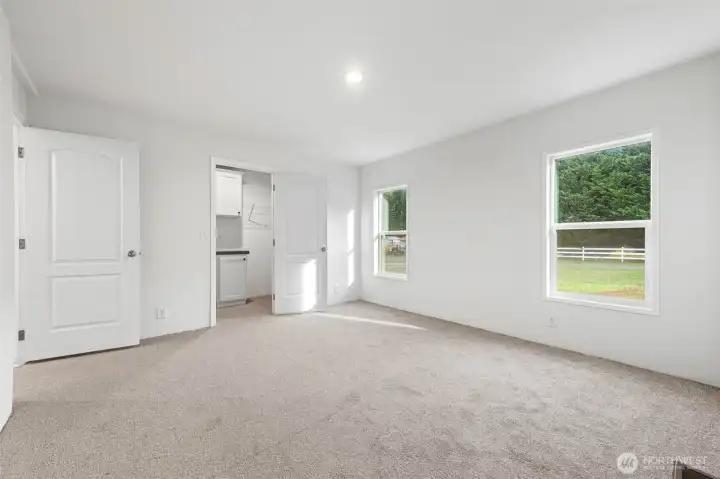 Large primary bedroom with a large walk-in closet and door to the left is primary bath.