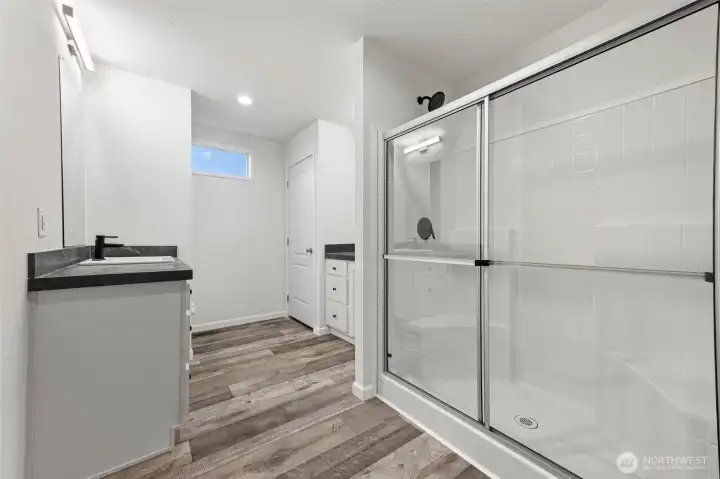 Another view of the primary bath, linen closet and commode on the other side of the sink to the left.