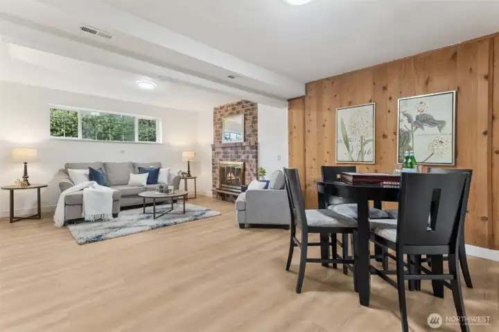 We love this super functional lower level rec-room! So warm, with the brick fireplace, new LVP flooring and wood paneling.