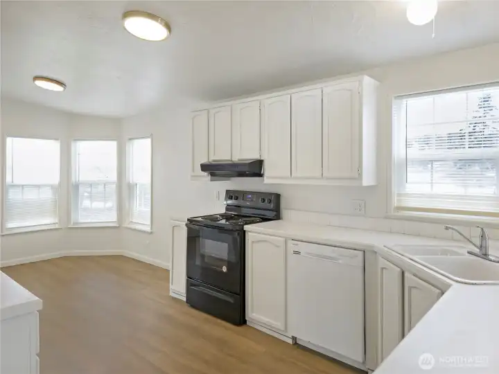 Bright and functional kitchen with updated flooring, ample cabinet space and newer range and hood. Custom blinds through out the home.