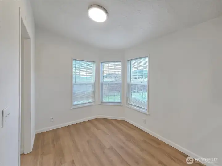 Sunny corner breakfast nook filled with natural light and framed by peaceful farm views—the perfect spot for morning coffee.