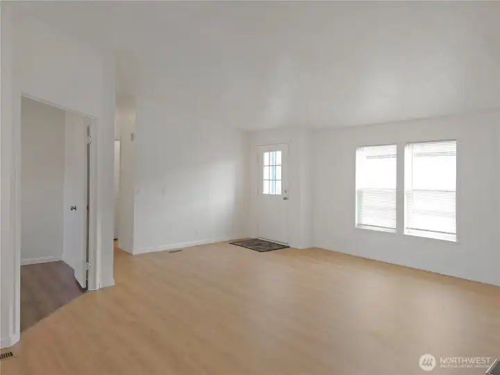 Spacious living room with fresh paint and new flooring, creating a comfortable gathering space for relaxing or entertaining.