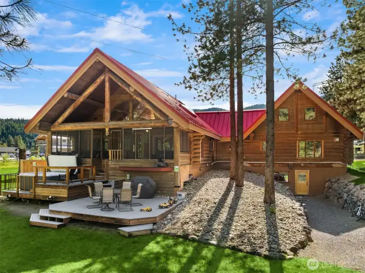 Striking riverfront retreat featuring a dramatic A-frame great room with expansive windows, warm timber accents, and seamless indoor-outdoor living. Thoughtfully designed outdoor spaces include a fire pit gathering area, covered patio, and direct access to the Wenatchee River—perfect for entertaining or relaxing in a peaceful, setting.