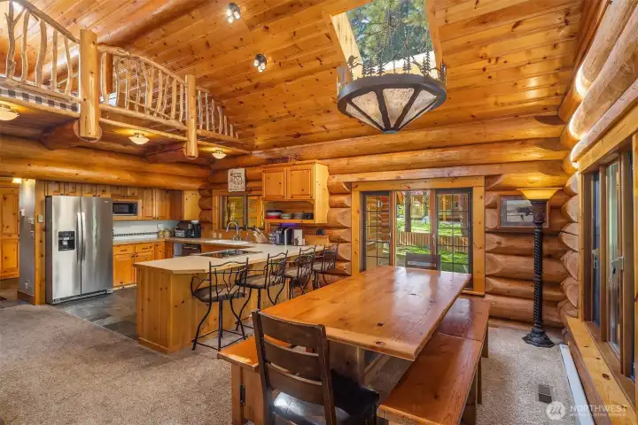 Dining area with exposed log beams, and large windows that fill the space with natural light—perfect for gathering and entertaining.