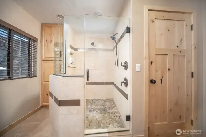 Glass enclose with travertine tile in the shower and floor.